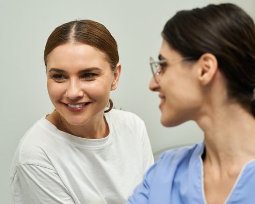 A healthcare professional discusses health concerns with a female patient in a cozy clinic.