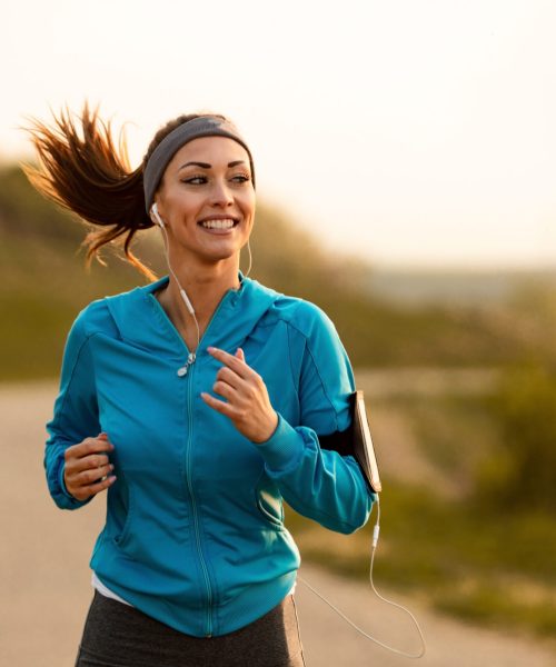 Dedicated athletic woman running in nature and dawn.